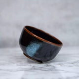 Bild in Galerie hochladen, Handgefertigte Matcha-Teeschale aus Keramik namens Chawan in den Farben Schwarz und Braun mit blauen Flecken